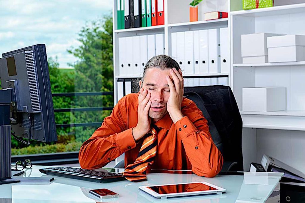 "Dying for a paycheque?" — good HR Managmement can breathe new life into your team 2 Over worked business man at desk Pivotal HR Solutions Blog