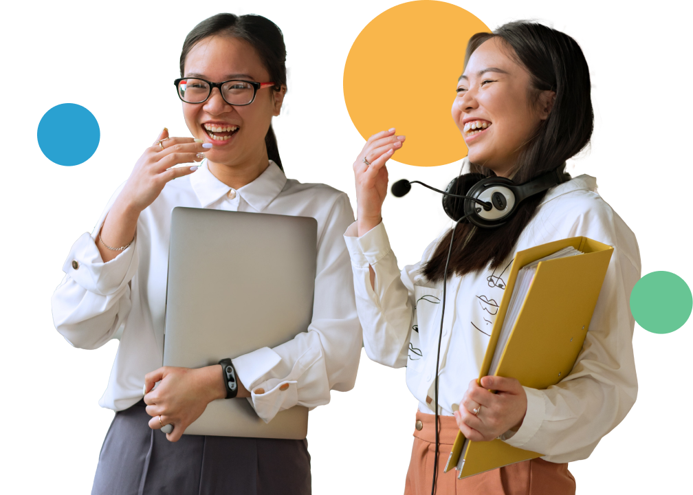 Two women laughing in office attire.