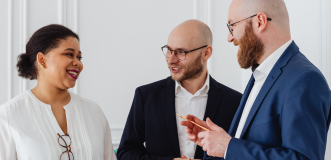 Two men with glasses and a woman talking