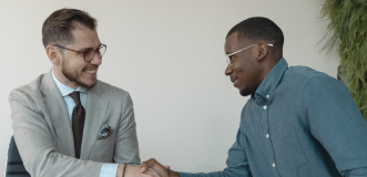 Two men in glasses shaking hands